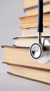 A stethoscope dangles off a pile of books, representing various laws that errors & omissions insurance can help safeguard against.