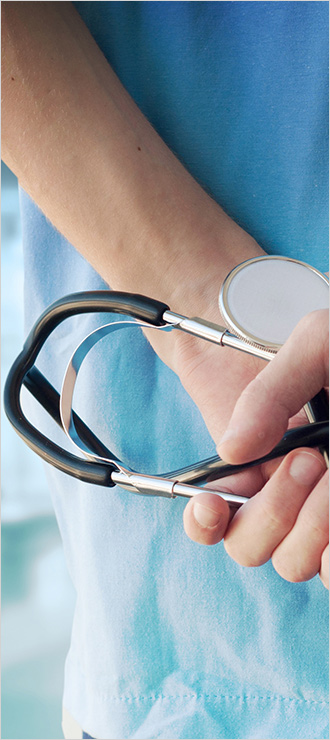 A close up of a physician holding a stethoscope. Stop loss insurance can help protect healthcare organizations from catastrophic claims.