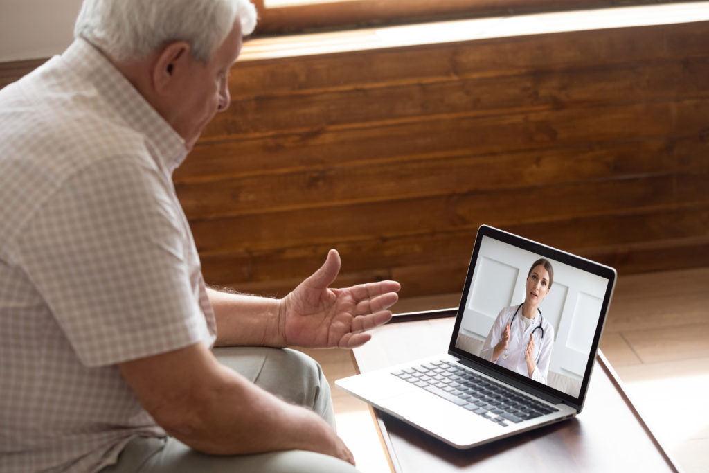 An elderly man consulting with doctor via computer video call