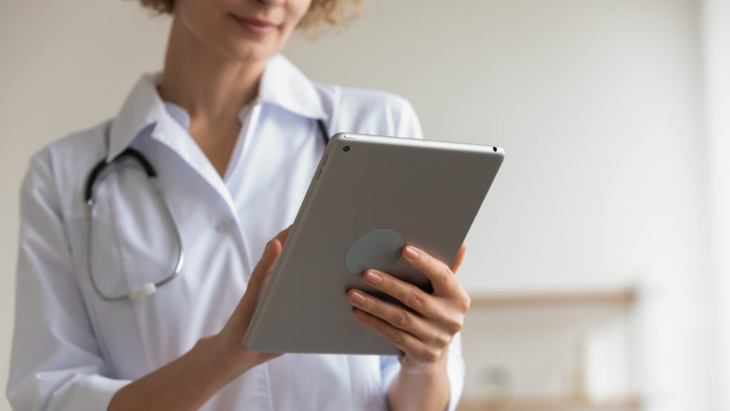 Female medical professional holds a digital tablet