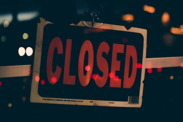 A close up of a "Closed" sign on a business.