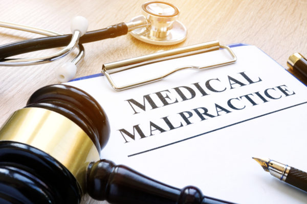 Clipboard with documents about medical malpractice, gavel and stethoscope