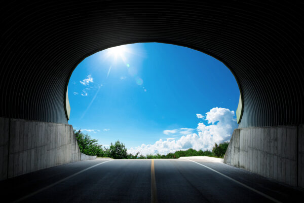 Sun shines outside a tunnel, representing a moderation of insurance premium prices.