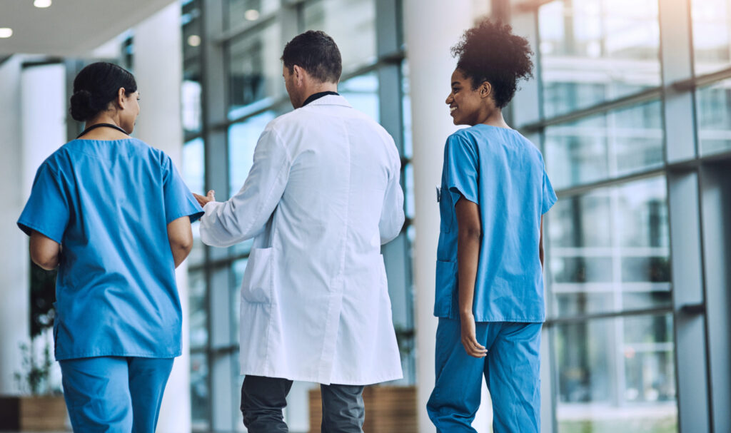 A medical team walking and talking together, representing the risk of nuclear medical malpractice verdicts.