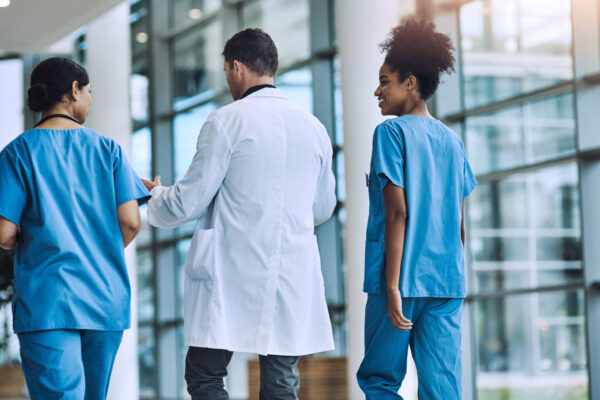 A medical team walking and talking together, representing the risk of nuclear medical malpractice verdicts.